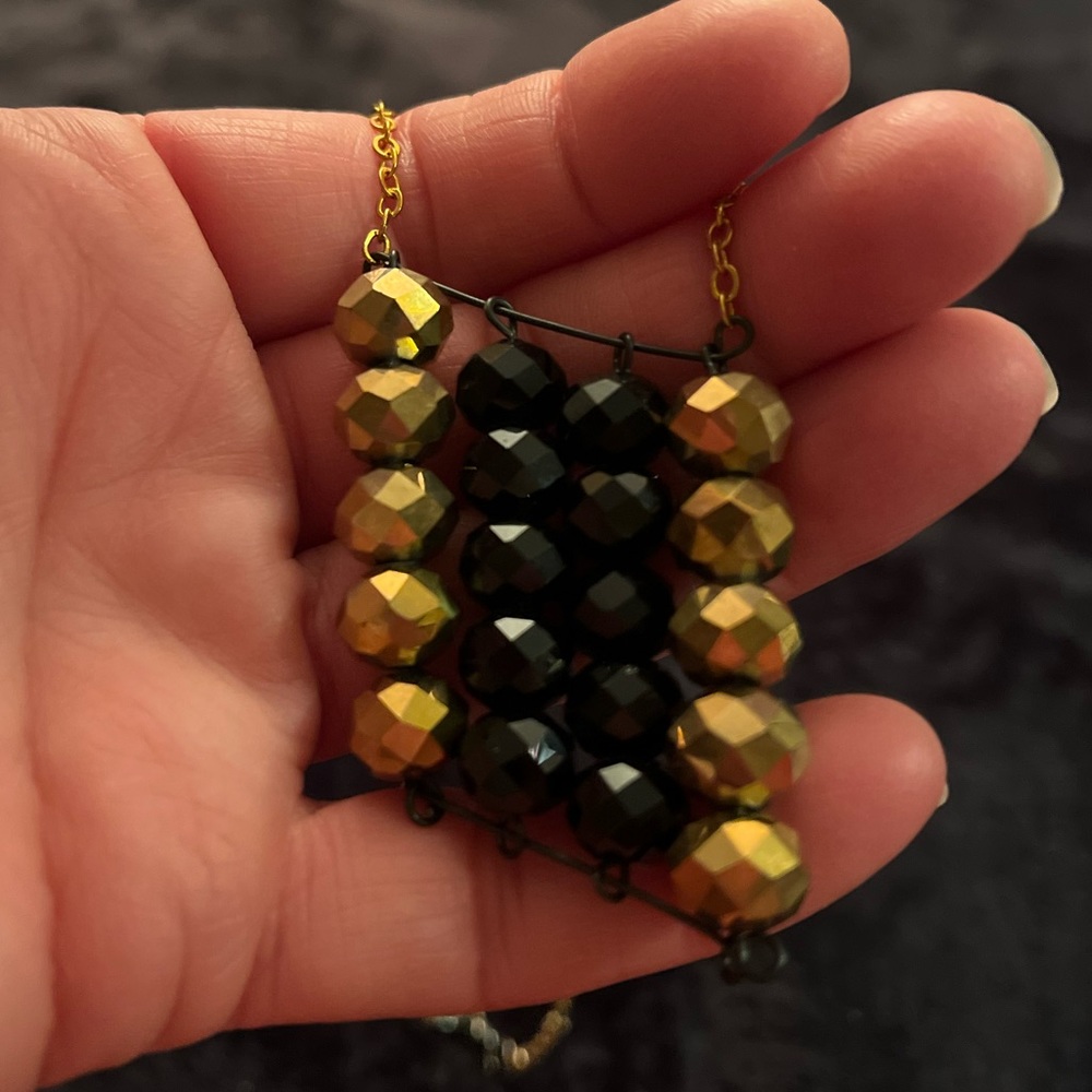 Handmade necklace with gold and black sparkle beads in the shape of a diamond